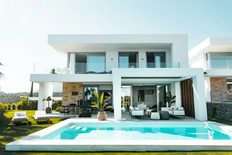 Villa blanca de dos plantas con piscina y jardín