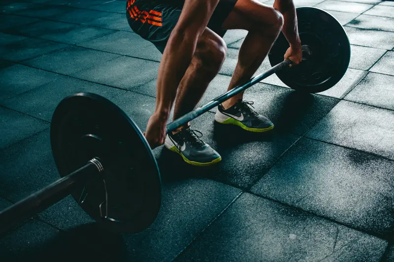 Atleta preparando un peso muerto con barra