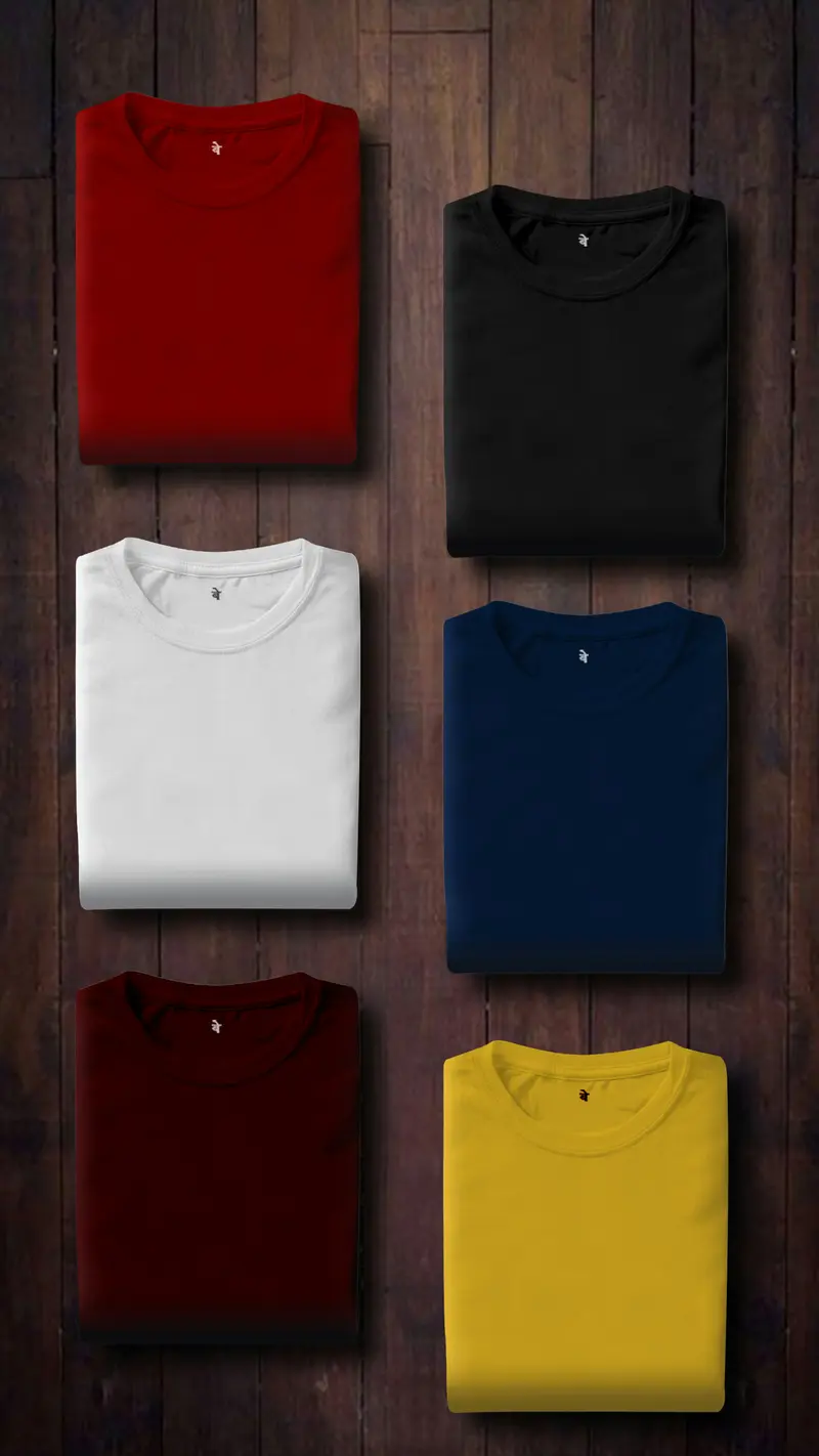 Dos camisetas dobladas, una blanca y una negra, sobre madera