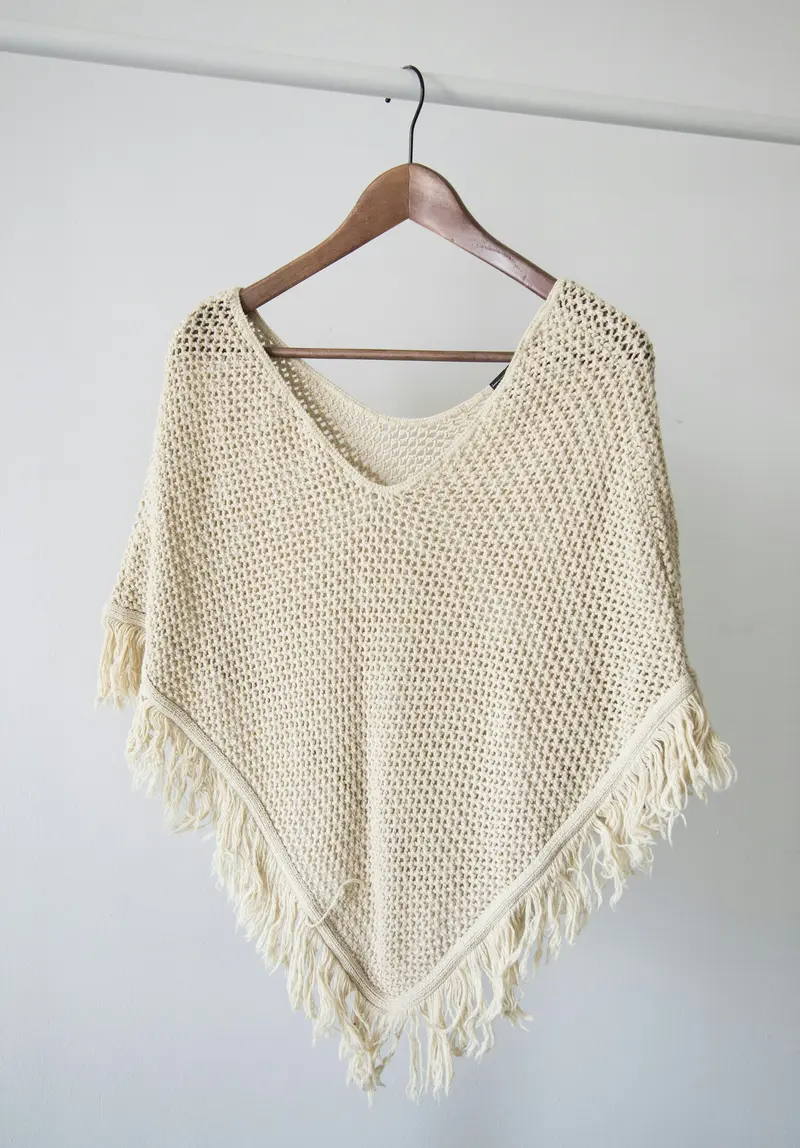 Poncho de punto calado color crudo con flecos