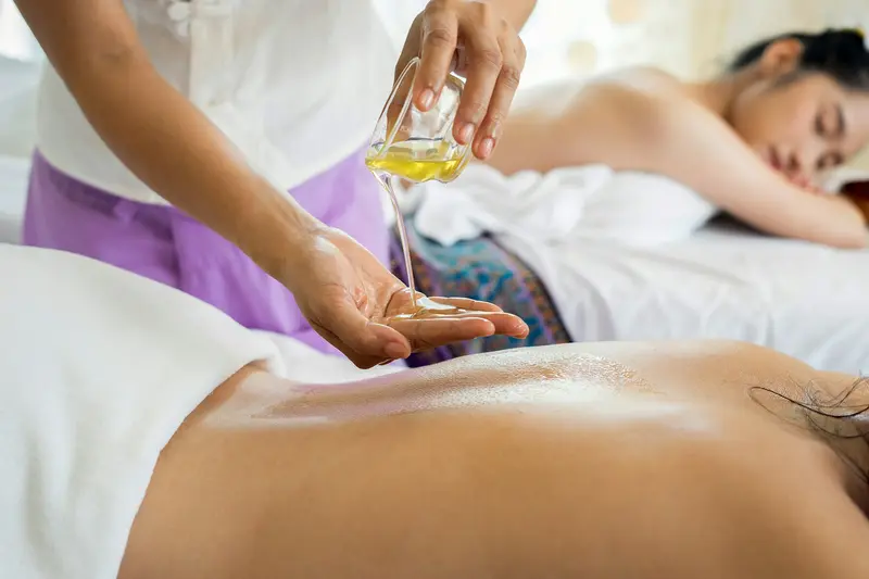 Aceite cayendo sobre las manos antes de un masaje