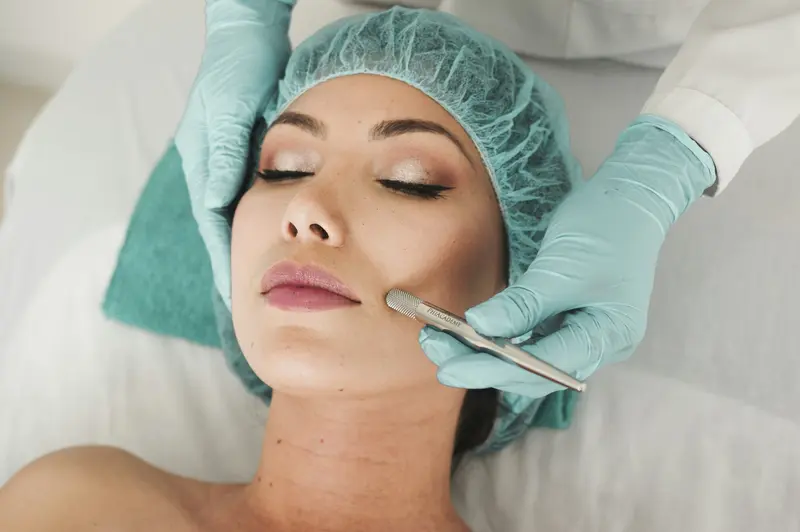 Profesional con guantes realizando un tratamiento facial