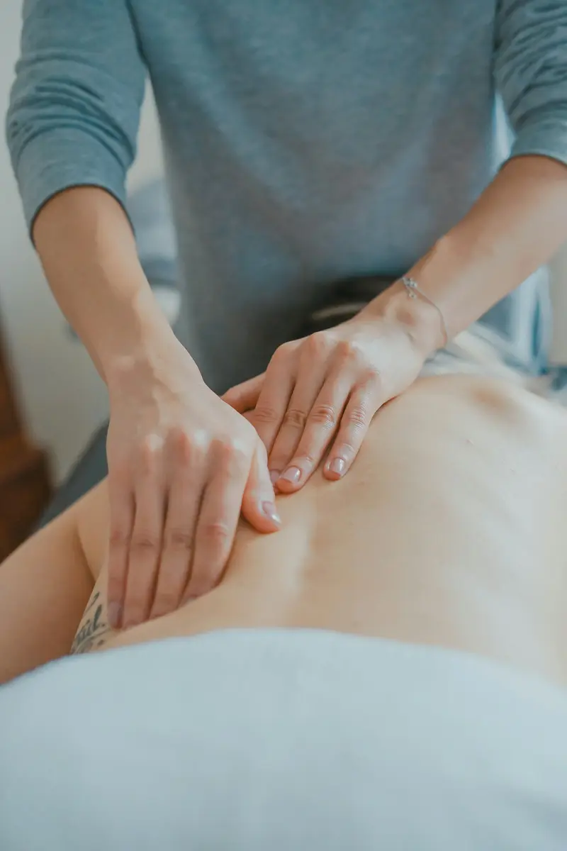 Manos realizando un masaje relajante en la espalda