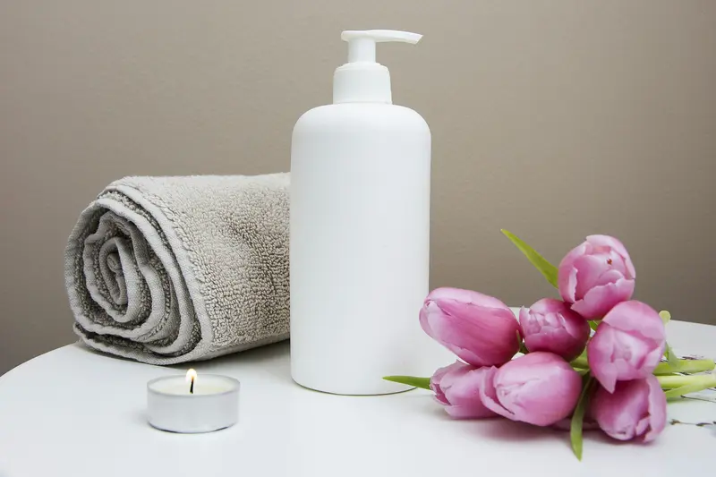 Toalla, vela y flores sobre una mesa de spa