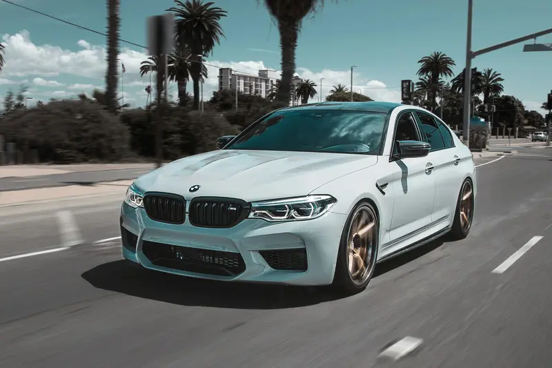 BMW M5 blanco circulando por una carretera